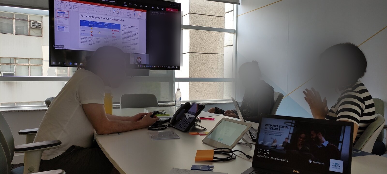 In-person and remote team members reviewing a wholesaler tool proposal together, February 2021