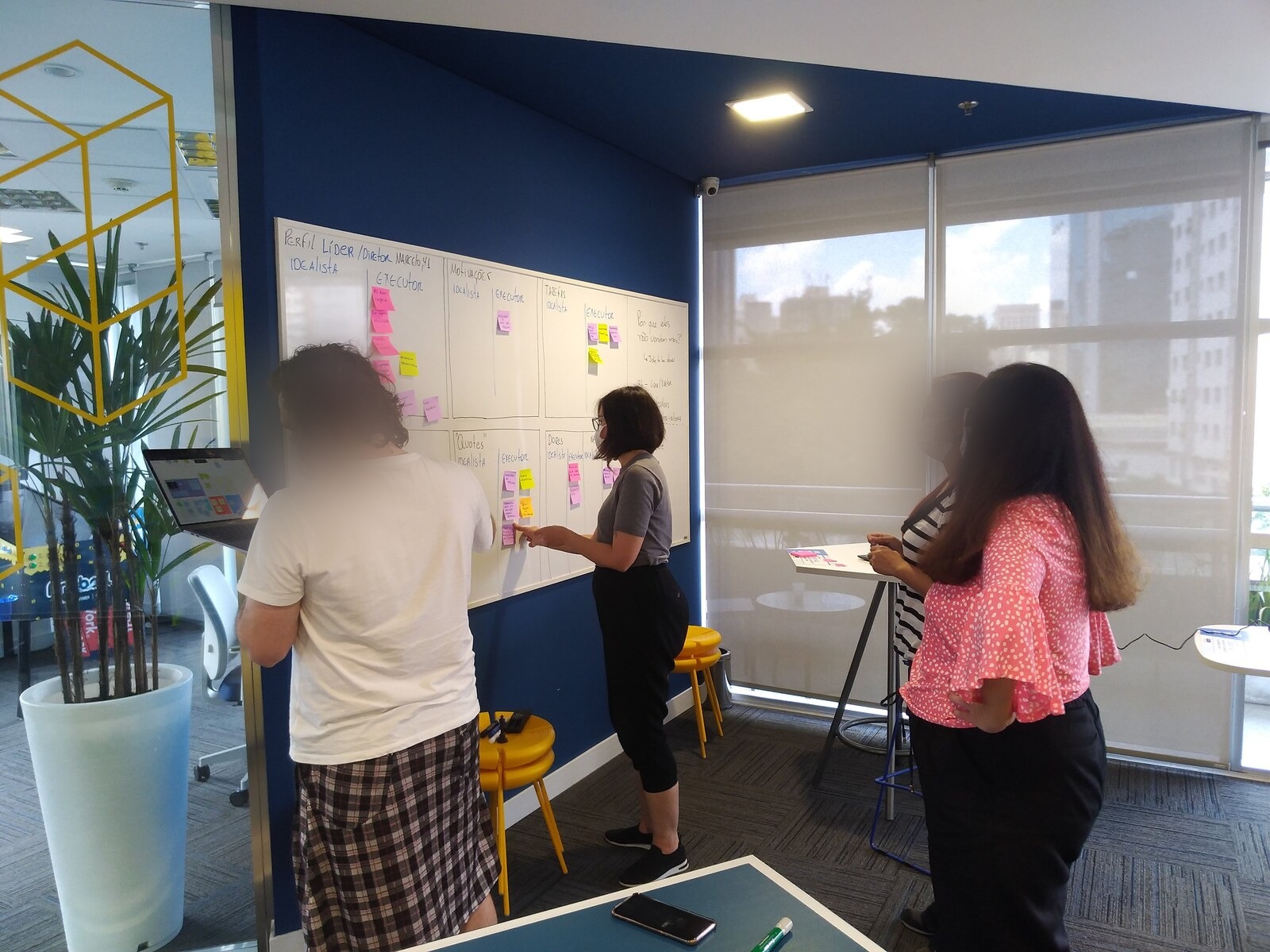 Team working on a physical whiteboard during a Jobs-to-Be-Done exercise